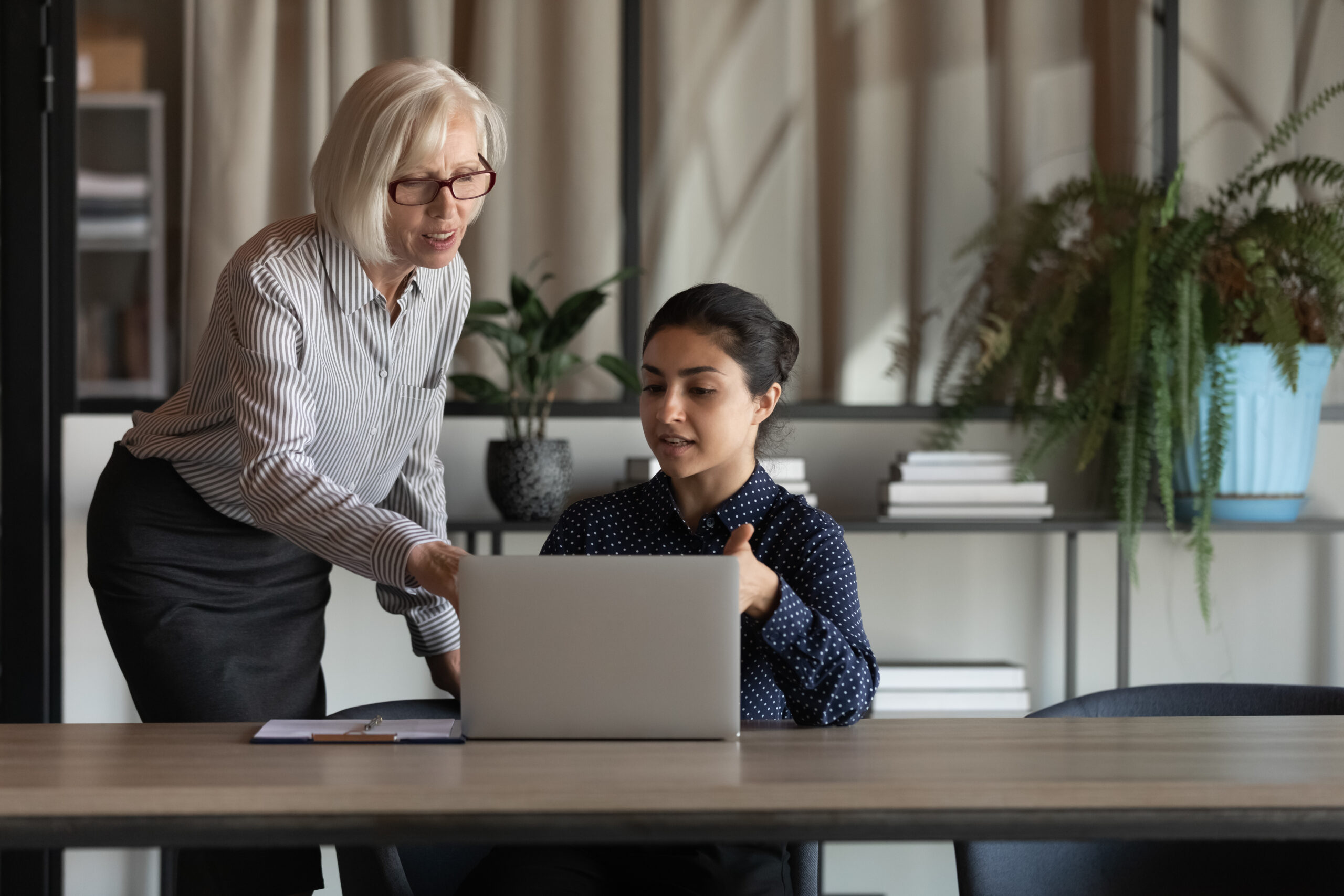 A workplace leader mentoring a young professional in the office.